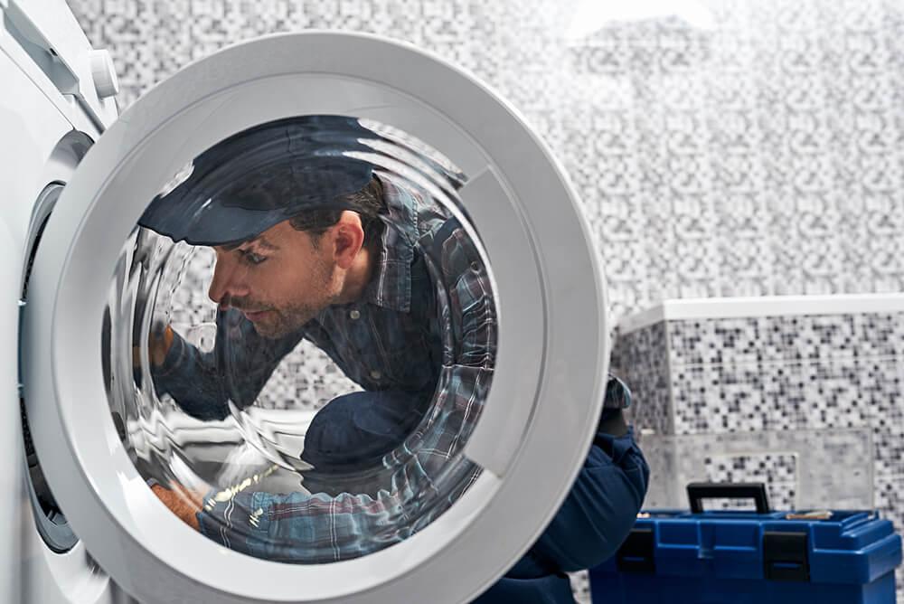 Professional washing machine maintenance service in Dubai showing technician performing comprehensive washer checkup and cleaning