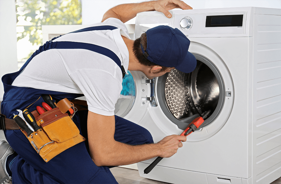 Professional washing machine repair technician servicing front-load washing machine in Dubai home