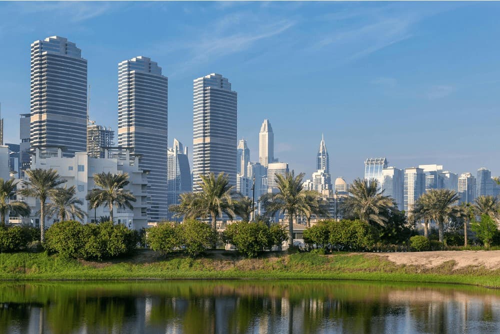 Residential towers beside a park lake near International City, Dubai