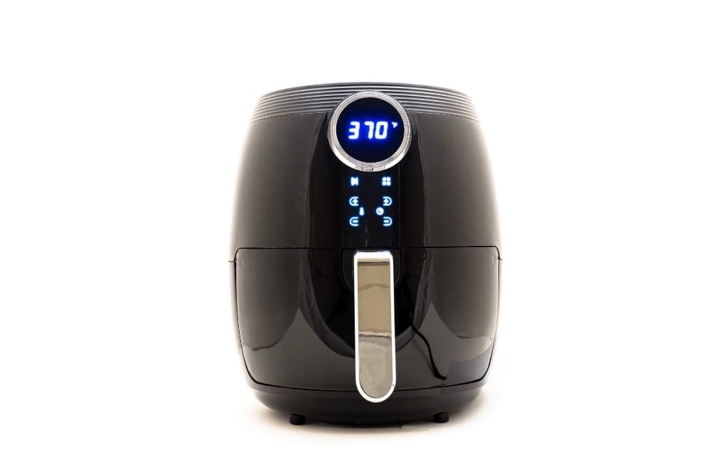 Black digital air fryer shown against a plain white background, showing its touch display, control dial and pull-out basket handle