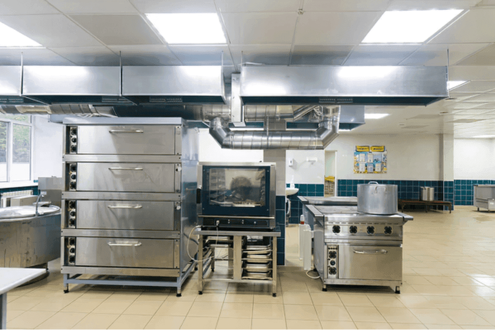 Commercial kitchen with deck ovens, a combi oven, a range and an extraction canopy