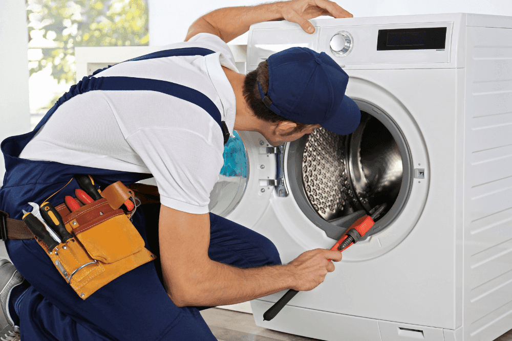 Technician working on the drum of an open front-loading washing machine